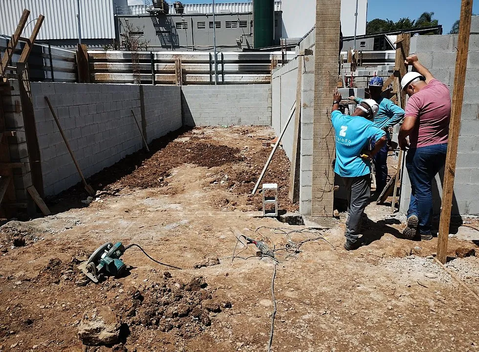 Equipe da Zgrada no canteiro, com material em obra